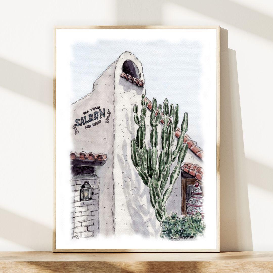 Watercolor-style art of Old Town Saloon in San Diego with cactus and Spanish colonial architecture, framed in a modern wooden frame. Historic Old Town San Diego artwork for Southwestern decor.