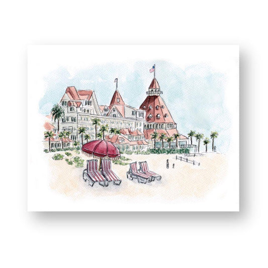 Watercolor print of the iconic Hotel del Coronado on a sunny beach with red umbrellas and lounge chairs in the foreground. This San Diego beach art captures the historic hotel's classic architecture, palm trees, and coastal charm, perfect for adding a touch of California decor to any space